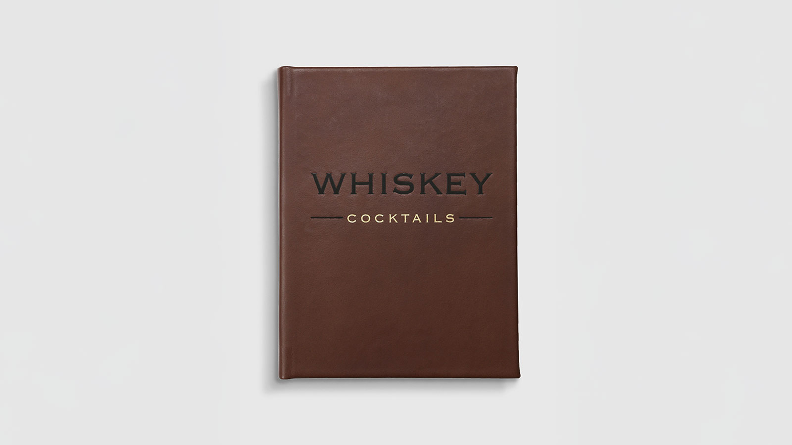 Brown leather-bound ‘Whiskey Cocktails’ book — a sophisticated library addition for the Best Whiskey Gifts for Men 2025.