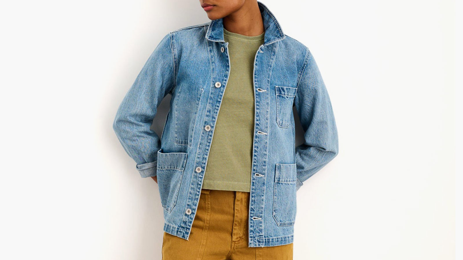 Classic denim chore jacket layered over a green tee, a versatile wardrobe essential in the best holiday gifts for women