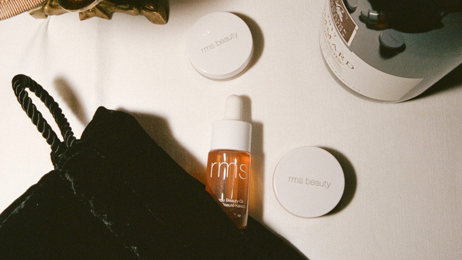 RMS Beauty skincare set featuring facial oil and makeup in soft lighting, a clean beauty favorite in the best holiday gifts for women