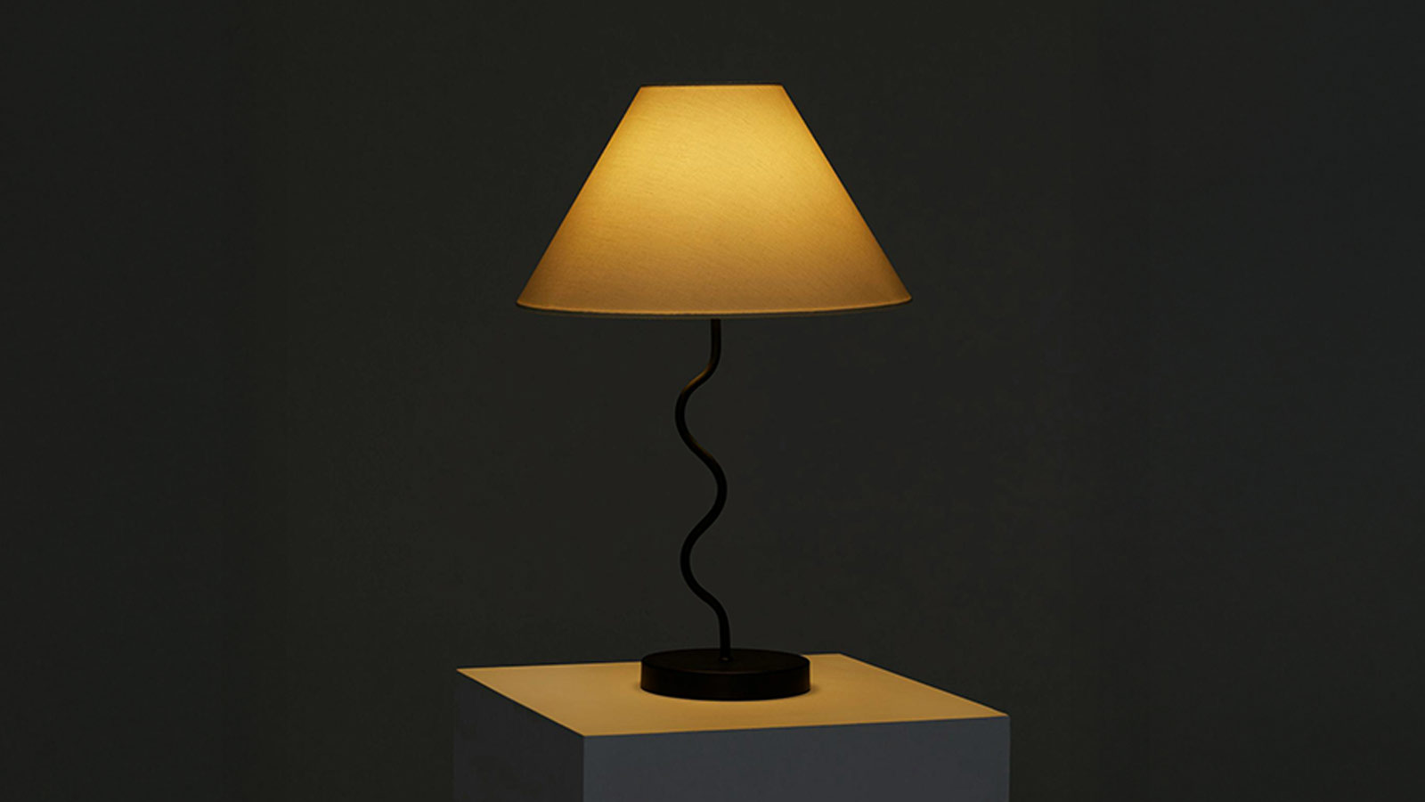 Sculptural squiggle desk lamp with a modern curved base and white shade — a perfect gift for design lovers.