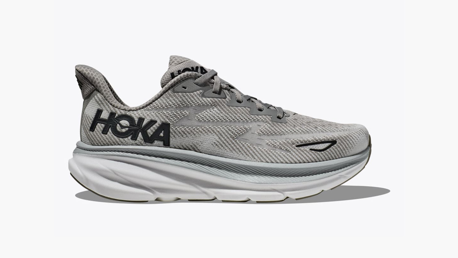 a gray running shoe with a thick white sole and the word "Hoka" on the side