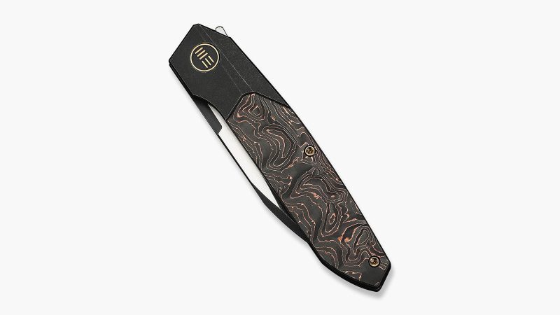 The WEKNIFE Brr15 has a rugged black titanium frame inlaid with copper foil.