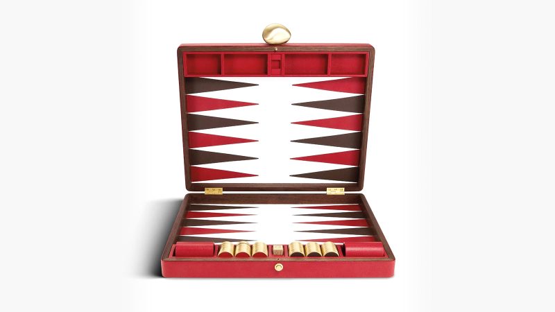 Assouline's Library Collection Backgammon Set features a luxurious walnut wood case and a multi-colored pebbled leather inlaid board.