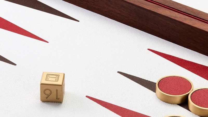 Assouline's Library Collection Backgammon Set features a luxurious walnut wood case and a multi-colored pebbled leather inlaid board.