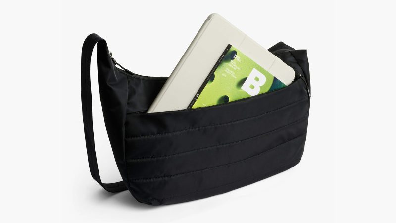 Bellroy’s Laneway Crescent Bag is a recycled nylon cross-body sling design featuring a wide-mouth zipper, internal tool belt pocket, quilted back panel, adjustable webbing strap, and AirTag sleeve.