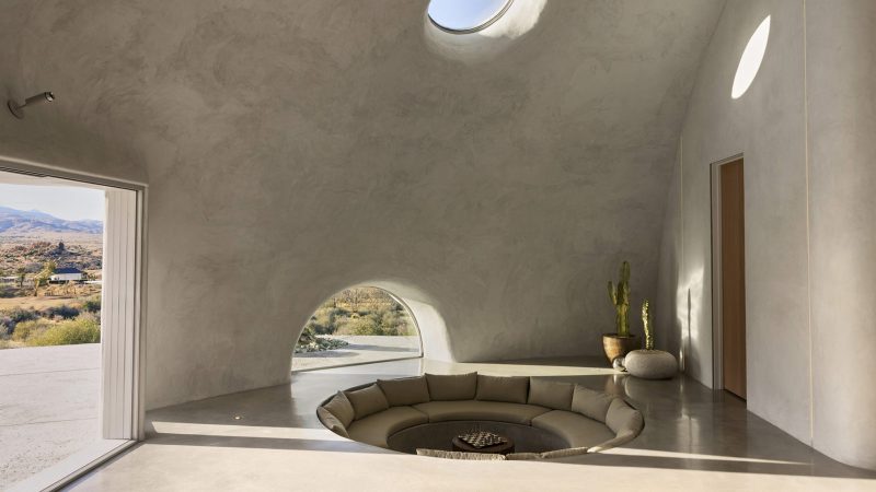 Sculptural concrete dome house in California’s High Desert, designed by Anastasiya Dudik, with curved monolithic exterior, saltwater pool, and minimalist brutalist interior built from concrete, stone, and plaster.