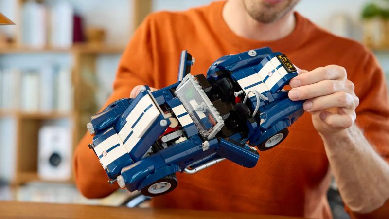 LEGO's Icons Shelby Cobra 427 S/C model car kit for adults features a blue body, white racing stripes, and a detailed V8 engine.