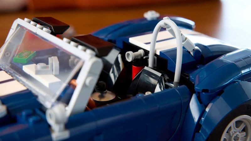 LEGO's Icons Shelby Cobra 427 S/C model car kit for adults features a blue body, white racing stripes, and a detailed V8 engine.
