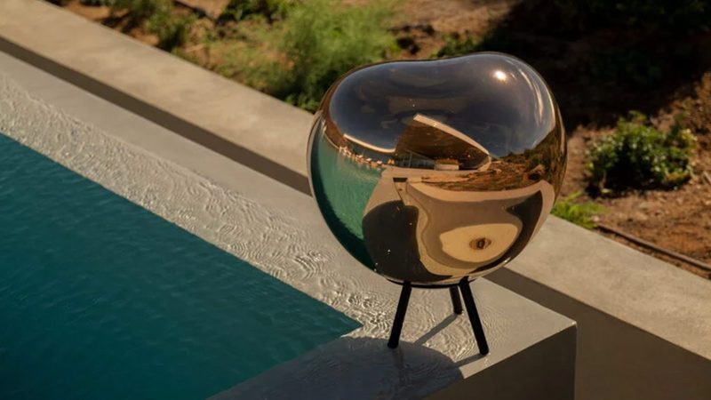 Tom Dixon's Melt Portable Lamp features a reflective mirror-finish shade, and a tripod base.
