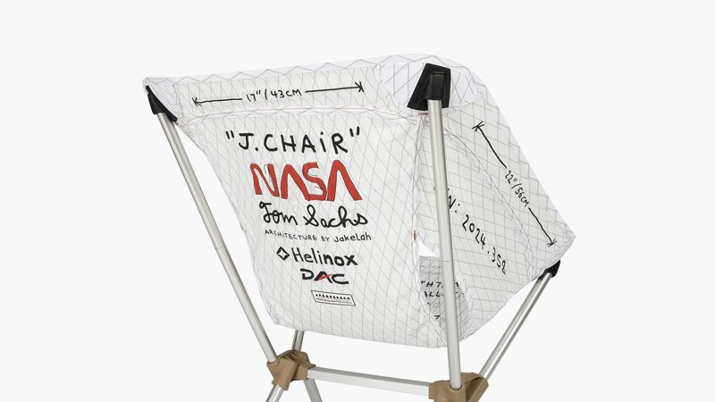 Tom Sachs J.Chair by Helinox features a raw DAC aluminum frame, NASA-inspired typography, and Vibram feet, blending industrial design with functional outdoor art.