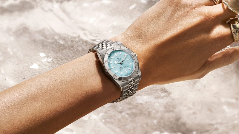Tudor's Black Bay 54 Lagoon Blue dive watch boasts a 37mm stainless steel case, sand-textured blue dial, and a five-link bracelet.