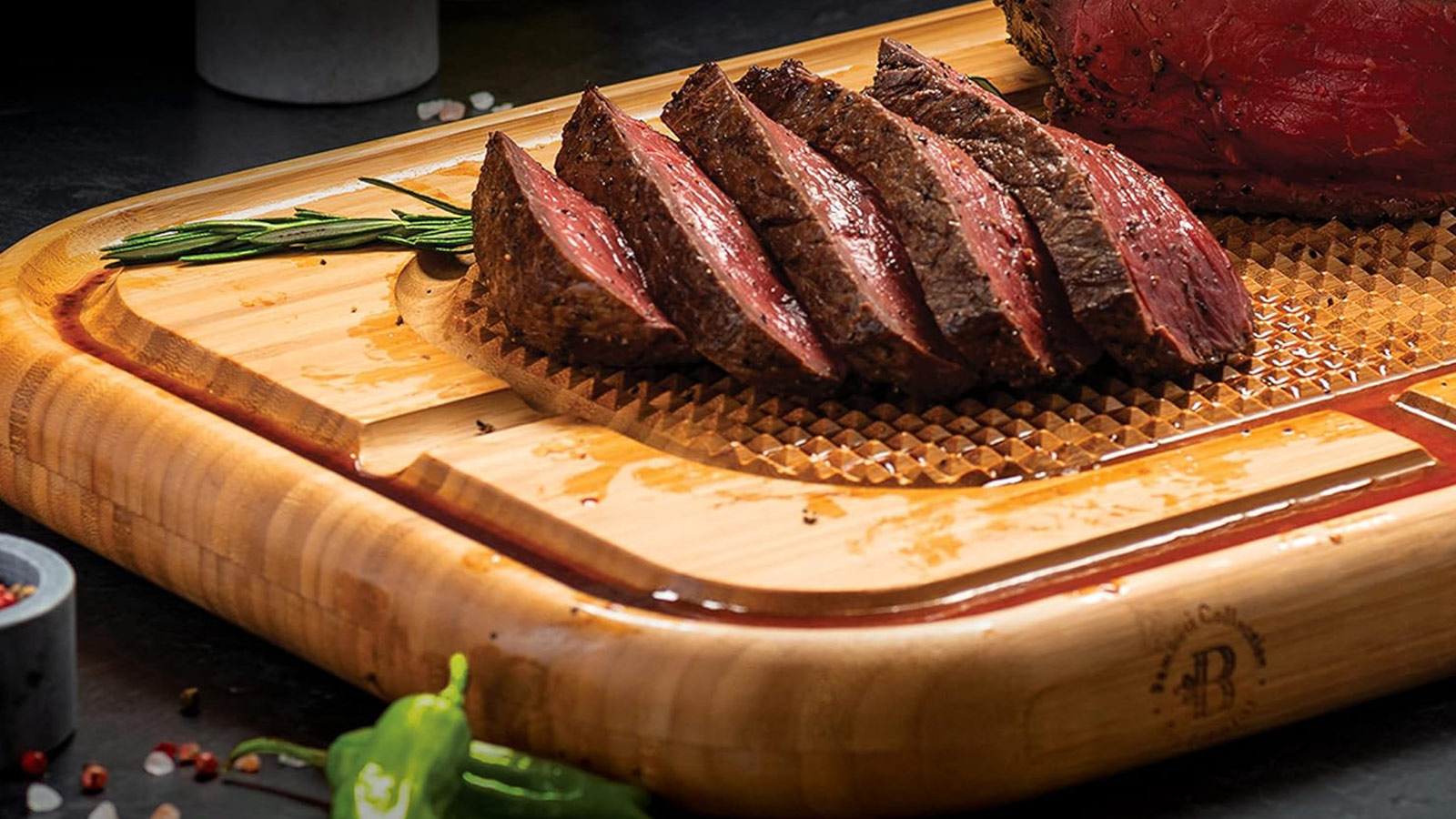 Bamboo meat cutting board with juice grooves and raised spikes—one of the best grilling tools for clean and precise carving.