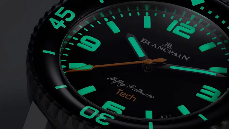 Blancpain Fifty Fathoms Tech 5029 dive watch with brushed titanium case, black dial, ceramic bezel, and bold orange rubber strap—combining professional diving specs with refined lifestyle appeal.