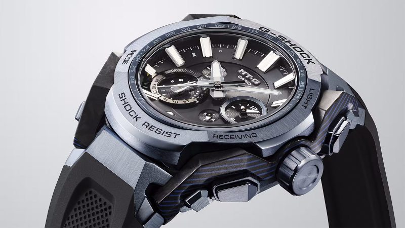Casio MT‑G B4000 blue‑gray watch showcasing a layered carbon‑fiber case, stainless steel bezel, rugged Dual Core Guard structure, and tech controls.