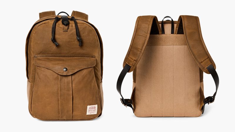The Filson Journeyman Backpack is crafted from durable Tin Cloth construction, with a padded laptop sleeve, and classic leather detailing for rugged elegance.