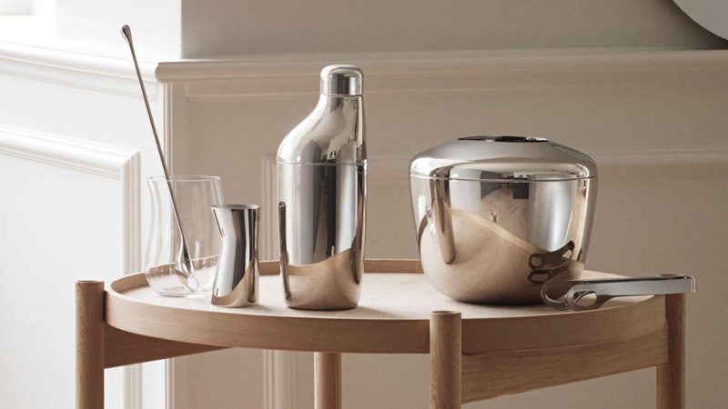 Modern silver bar tools on a wooden bar cart.