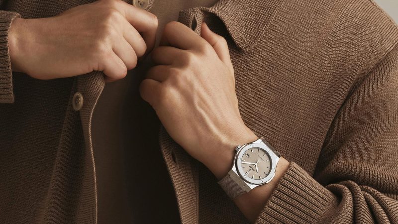 Hublot Classic Fusion Essential Taupe in titanium with sunburst taupe dial, polished bezel, and textured strap in 42mm and 45mm sizes.