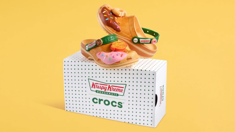 Krispy Kreme x Crocs Classic Clogs feature donut glaze-inspired design, sprinkle-themed Jibbitz charms, and co-branded heel straps.