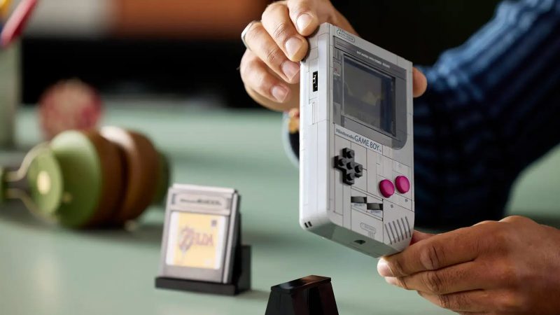 LEGO Game Boy model kit with 421 pieces shown assembled, featuring accurate buttons, interchangeable Zelda and Mario cartridges, lenticular screen options, and a custom display stand—perfect for retro gaming fans and collectors.