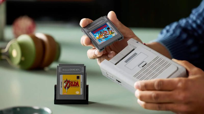 LEGO Game Boy model kit with 421 pieces shown assembled, featuring accurate buttons, interchangeable Zelda and Mario cartridges, lenticular screen options, and a custom display stand—perfect for retro gaming fans and collectors.