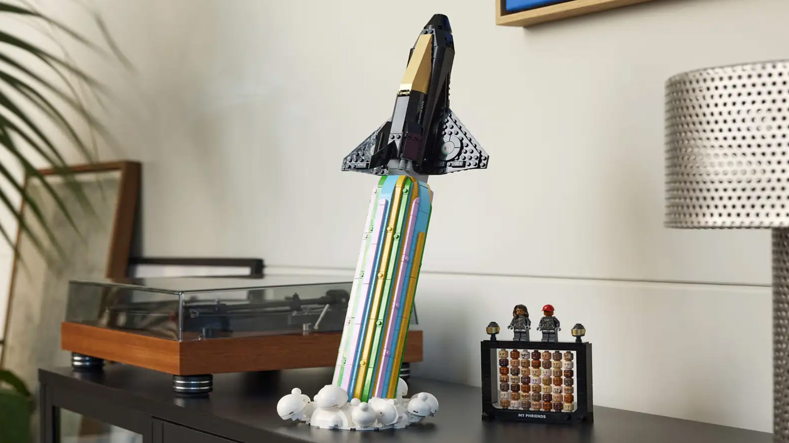 LEGO spaceship blasting off in a rainbow plume from Pharrell’s “Over the Moon” set—perfect for creative minds and one of the Best LEGO Sets for Adults 2025.