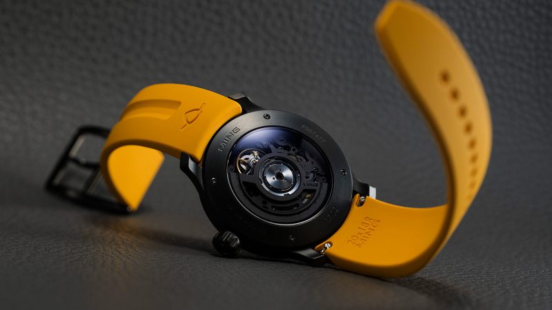The MING 37.02 Monolith limited-edition DLC-coated minimalist watch with luminous sapphire dial, Sellita SW300.M1 movement, and mango FKM rubber strap.