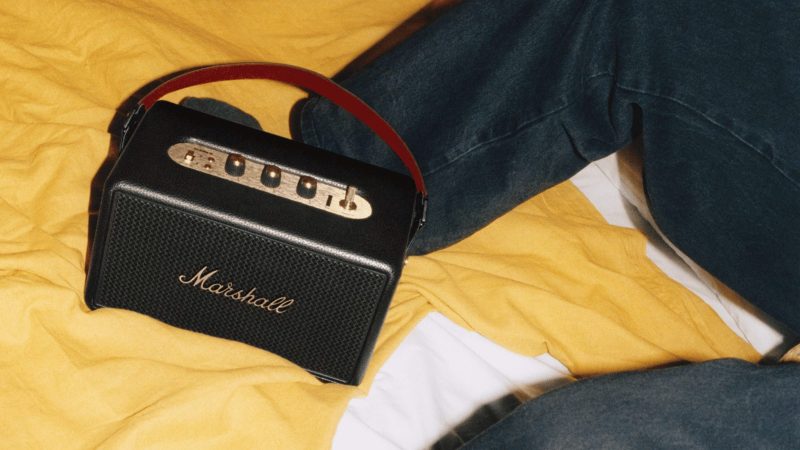 Marshall Kilburn III portable speaker with gold control panel, red velvet strap, and rugged speaker grille delivering 360° sound.