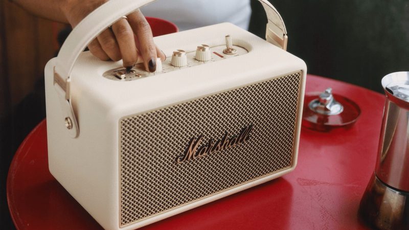 Marshall Kilburn III portable speaker with gold control panel, red velvet strap, and rugged speaker grille delivering 360° sound.