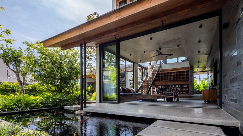 Exterior and interior views of OM House by AN NAM Architecture, showcasing sustainable sandstone walls, verdant gardens, and minimalist modern Vietnamese architecture designed for tranquility.