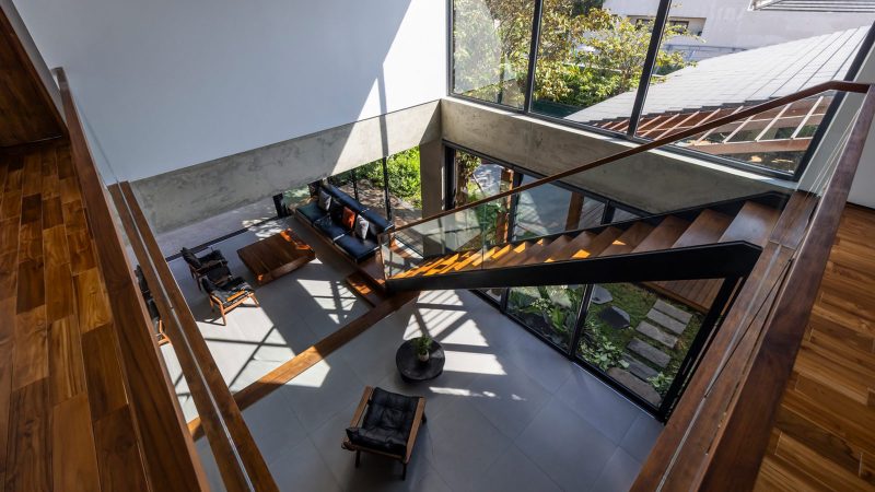 Exterior and interior views of OM House by AN NAM Architecture, showcasing sustainable sandstone walls, verdant gardens, and minimalist modern Vietnamese architecture designed for tranquility.