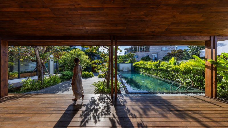 Exterior and interior views of OM House by AN NAM Architecture, showcasing sustainable sandstone walls, verdant gardens, and minimalist modern Vietnamese architecture designed for tranquility.
