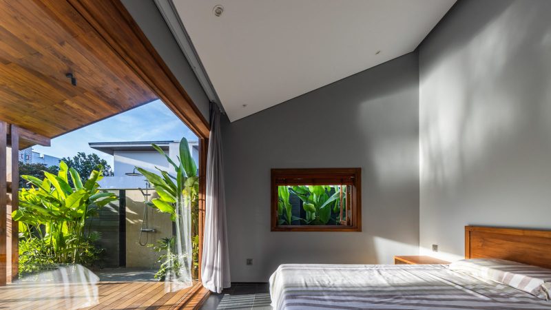 Exterior and interior views of OM House by AN NAM Architecture, showcasing sustainable sandstone walls, verdant gardens, and minimalist modern Vietnamese architecture designed for tranquility.