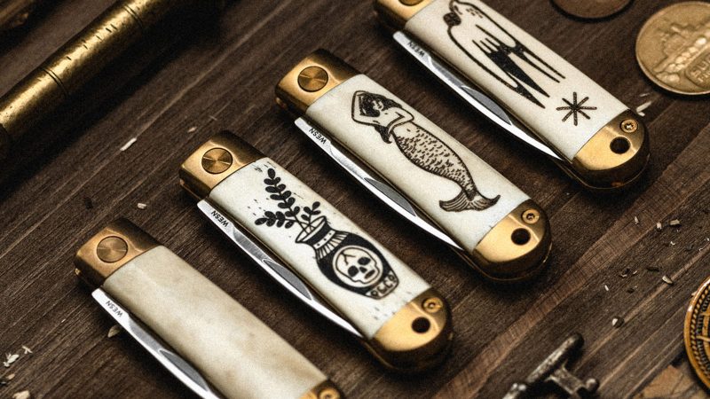 The WESN x P&Co. Scrimshaw Henry pocket knives feature laser-etched tattoo-style artwork on titanium handles, blending EDC functionality with heritage design.