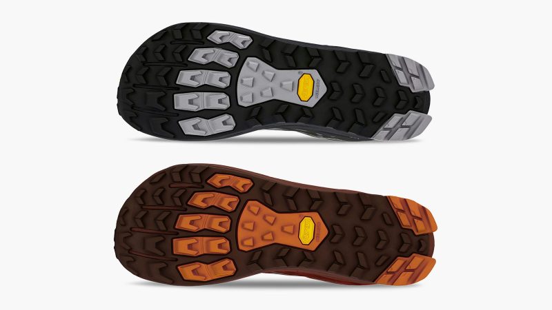 Altra x and wander Lone Peak 9+ trail shoe with alpine graphic overlays, Vibram Megagrip outsole, zero-drop platform, and bold orange and black colorways.