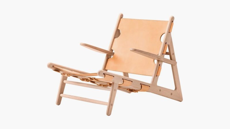 The Fredericia Hunting Chair in soaped oak with saddle leather, designed by Børge Mogensen, showcases minimalist Danish craftsmanship and luxury seating.