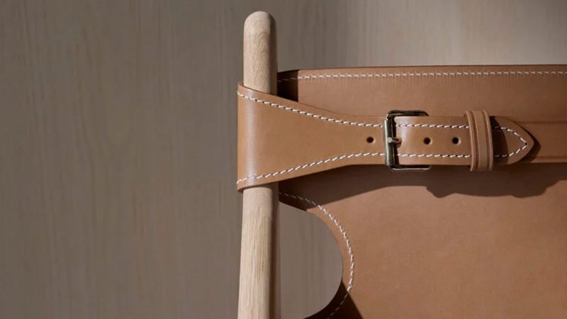 The Fredericia Hunting Chair in soaped oak with saddle leather, designed by Børge Mogensen, showcases minimalist Danish craftsmanship and luxury seating.