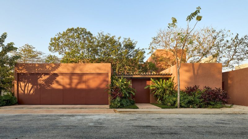 K’ab House by Lessmore Group, a Yucatán residence that combines rustic terracotta blocks, glass details, and lush greenery into a serene architectural retreat.