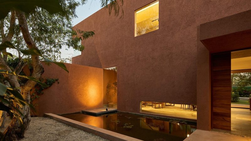 K’ab House by Lessmore Group, a Yucatán residence that combines rustic terracotta blocks, glass details, and lush greenery into a serene architectural retreat.
