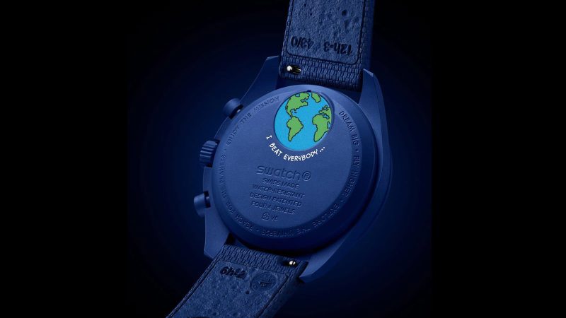 Omega x Swatch Mission to Earthphase Moonshine Gold watch with navy Bioceramic case, Moonshine Gold moon indicators, and UV-reactive Snoopy art.