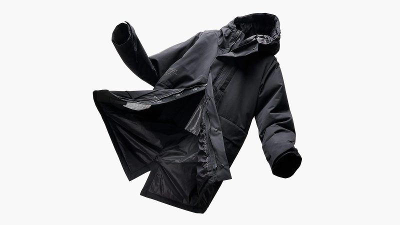 SPC/LST Revenant Weatherproof Parka in black with oversized fit and drop-tail hem, showcasing recycled materials, PrimaLoft insulation, and technical weatherproof design.