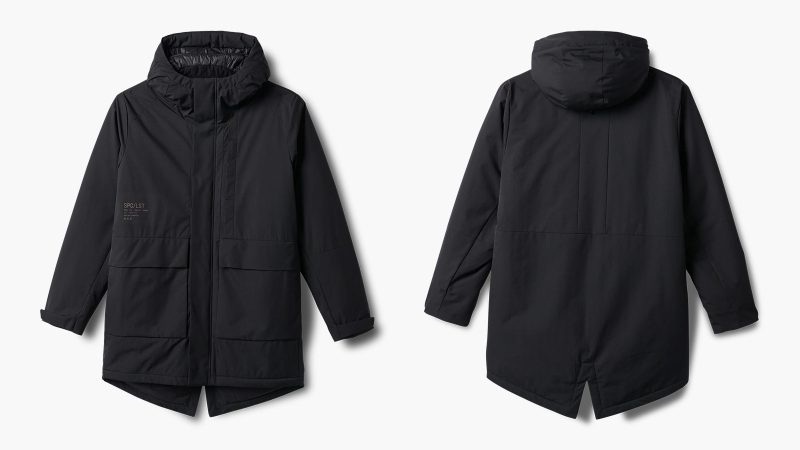SPC/LST Revenant Weatherproof Parka in black with oversized fit and drop-tail hem, showcasing recycled materials, PrimaLoft insulation, and technical weatherproof design.