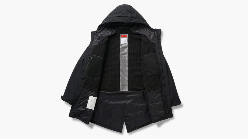 SPC/LST Revenant Weatherproof Parka in black with oversized fit and drop-tail hem, showcasing recycled materials, PrimaLoft insulation, and technical weatherproof design.