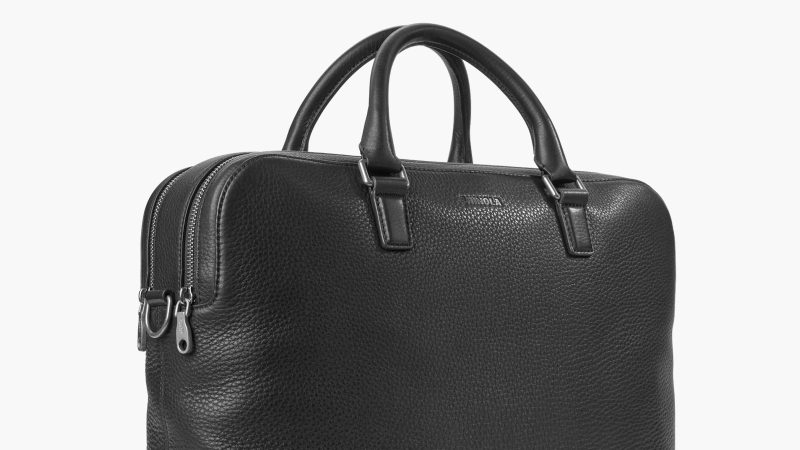 Shinola Double Zip Briefcase in premium Navigator leather with dual compartments, a padded laptop sleeve, and an adjustable strap for work and travel.