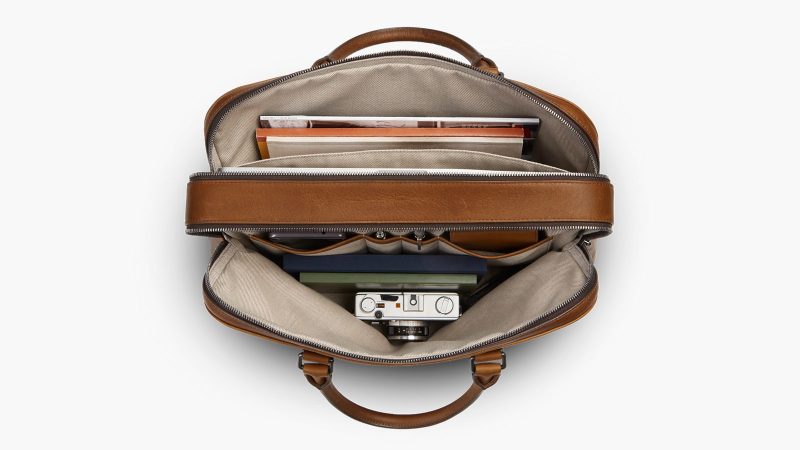 Shinola Double Zip Briefcase in premium Navigator leather with dual compartments, a padded laptop sleeve, and an adjustable strap for work and travel.
