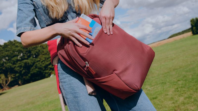 Troubadour Neo Backpack features a waterproof coating, a laptop sleeve, and a lightweight design for travel and commuting.