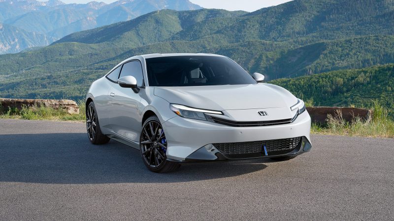 The 2026 Honda Prelude hybrid-electric sports coupe features a wide stance, flared fenders, Berlina Black wheels, and sleek GT styling.