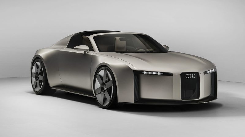 The Audi Concept C is an all-electric two-seat roadster featuring a vertical frame grille, a titanium finish, and a retractable hardtop, showcasing Audi’s next-generation design.