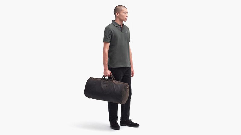 Barbour Waxed Holdall travel bag in waxed cotton with leather trim, a durable weekender for men, featuring a heritage-inspired design for stylish commuting and travel.
