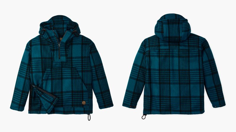 Filson’s Mackinaw Wool Anorak features durable 100% wool construction, adjustable hood and cuffs, a kangaroo pocket, and a quarter-zip front for versatile cold-weather performance.