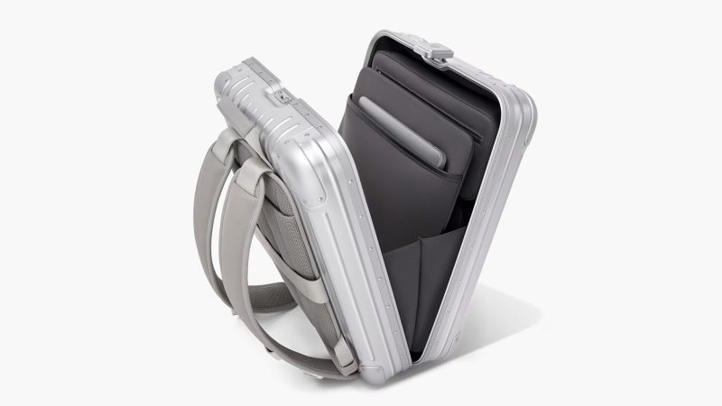 RIMOWA Original Backpack in silver anodized aluminum featuring a secure lock system, a laptop compartment, a removable pouch, and a suitcase sleeve.